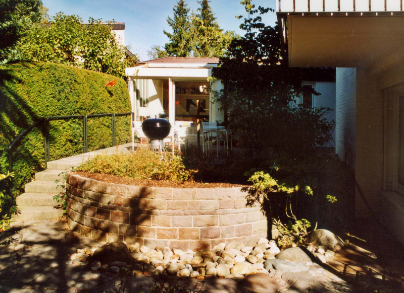 Früher: eine steinernde Terrasse; das Pflanzbeet wirkt nicht nur sehr massiv, es verdeckt auch mit der Bepflanzung unnötig den Blick in den Garten.