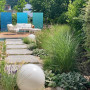 Den Weg zur neuen Terrasse begleiten blühende Stauden und Gräser